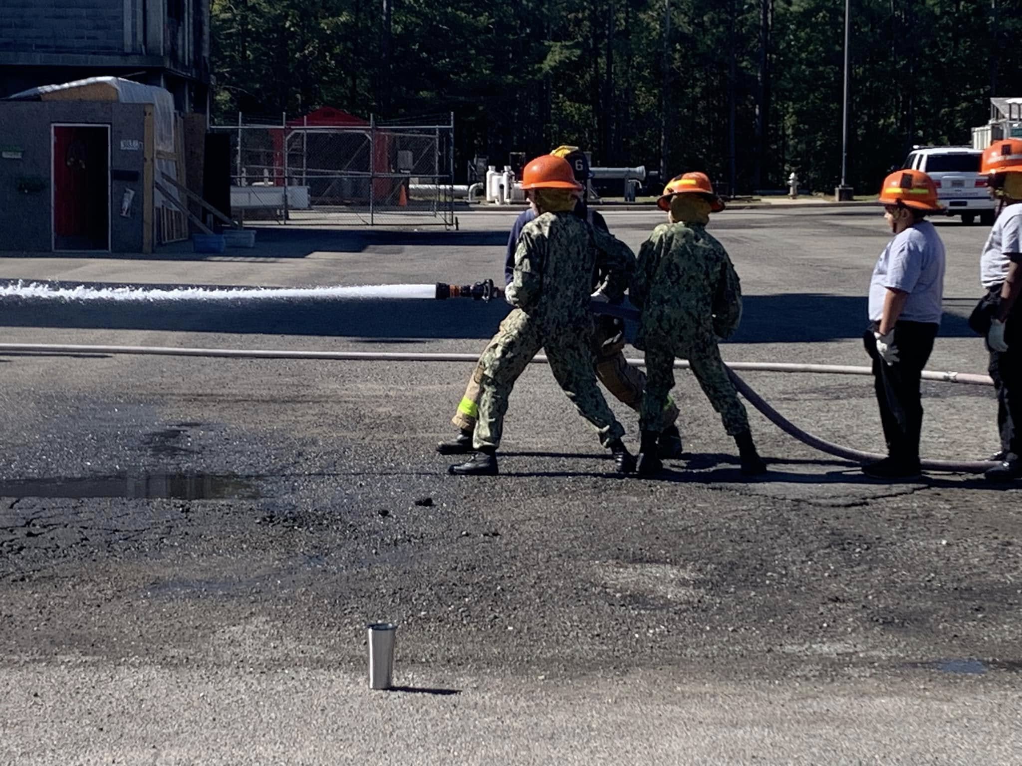 Two AMERICA Division cadets operating a live fire hose during training