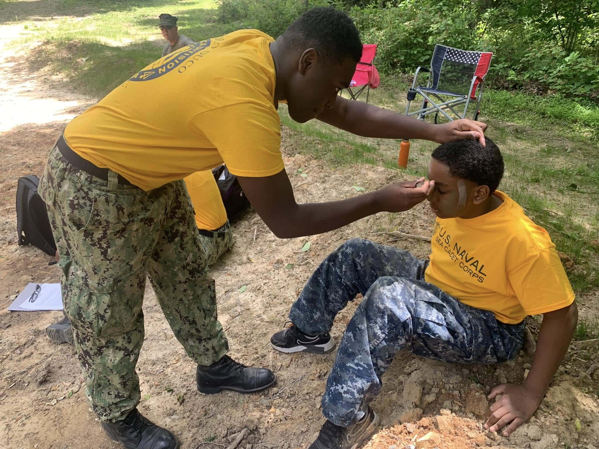 Experienced Sea Cadet mentoring a younger cadet during training