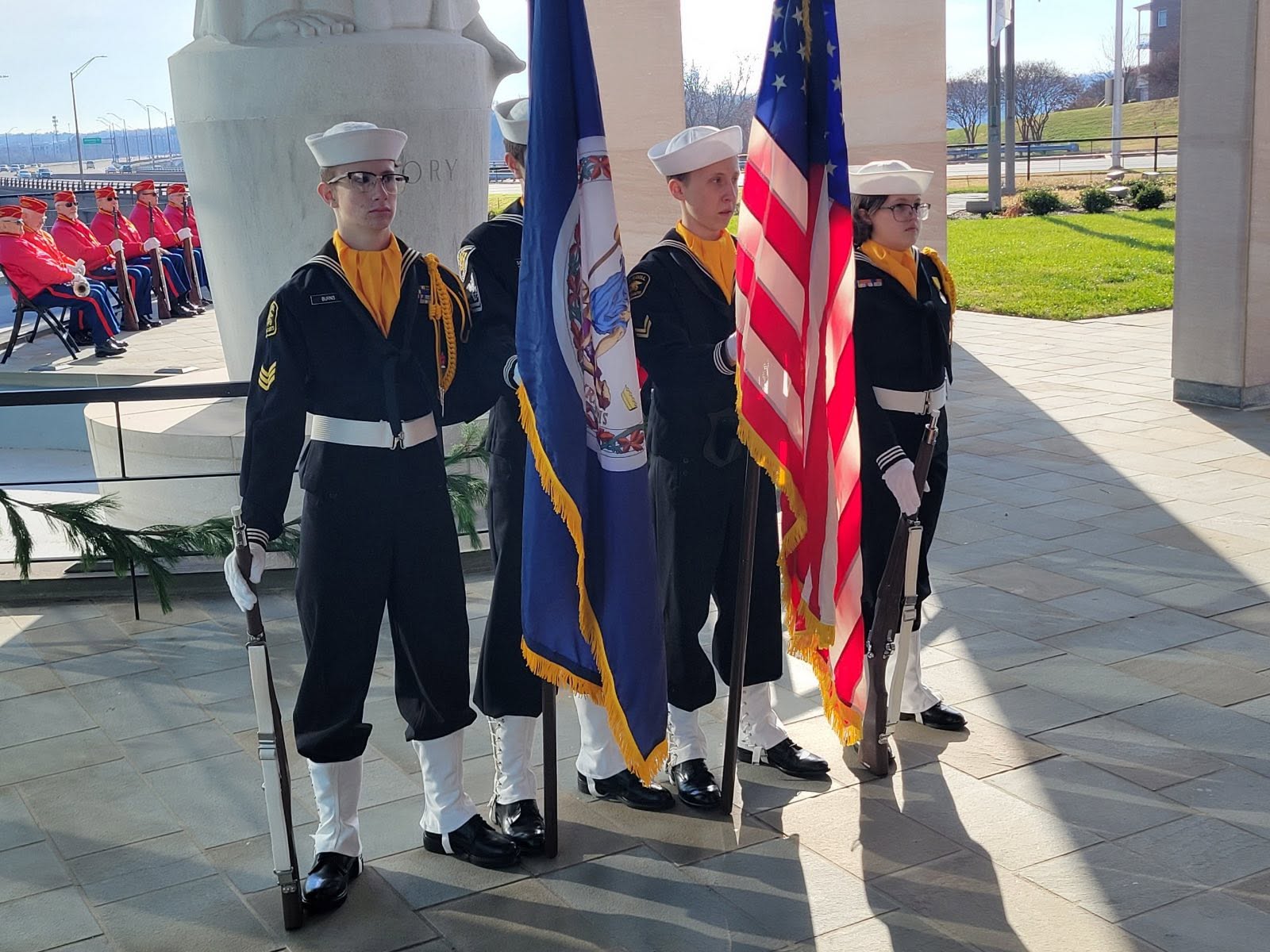 Color guard in dress blues with Virginia and American flags at a memorial